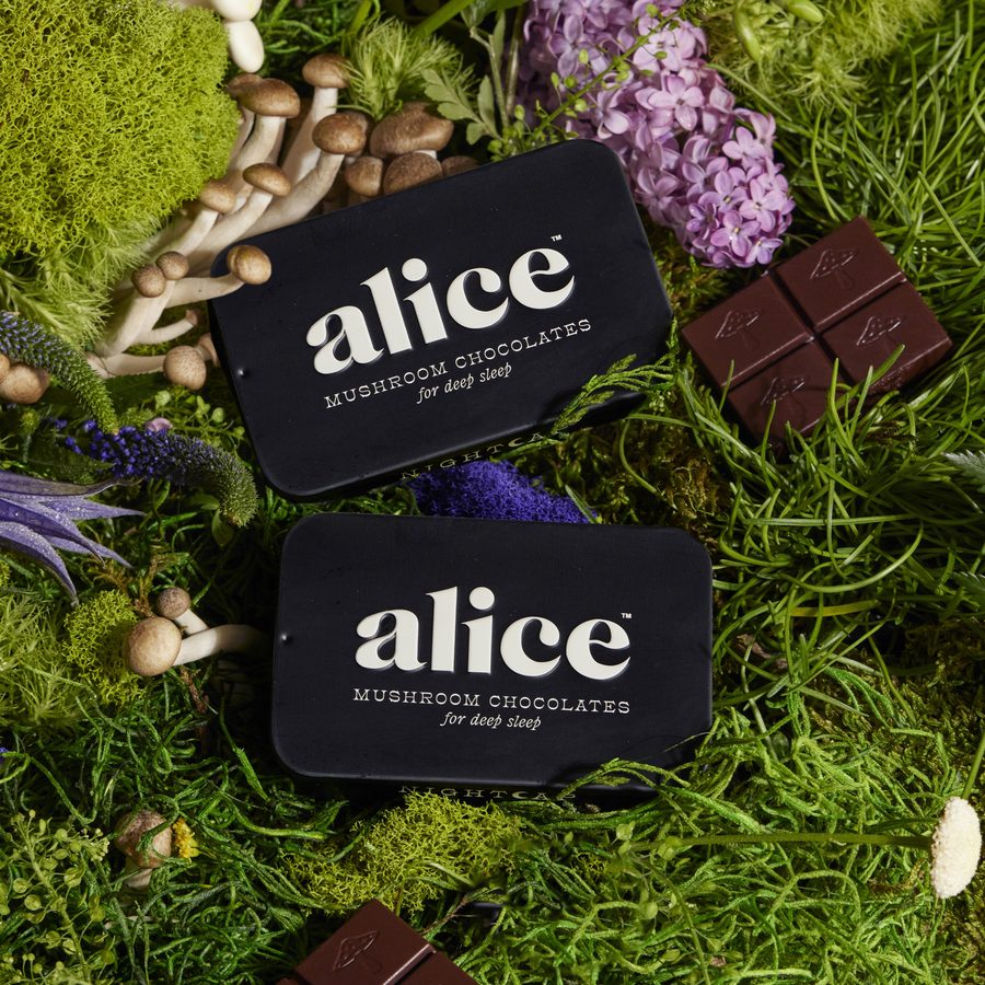 two black Nightcap tins and dark chocolate squares on moss